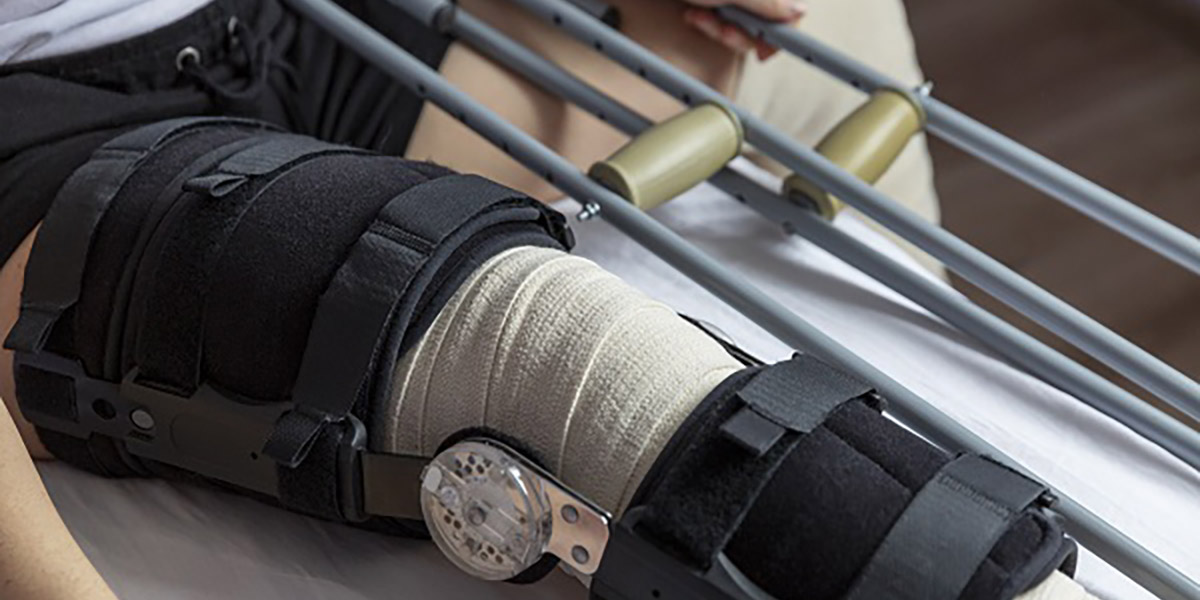 Man in leg brace with crutches - close up of leg